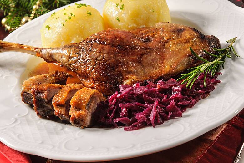 Knusprig gebratene Entenkeule mit Kartoffelklößen und Blaukraut – festliches Gericht in der JOSKA Themenwoche „Ganserl- und Enten-Essen“.