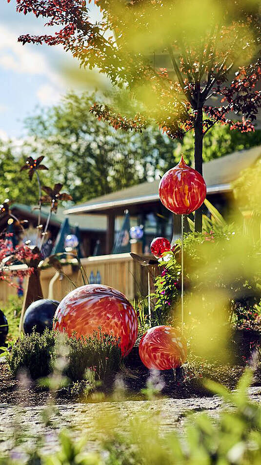 he Glaskugeln und Pflanzenkunst im Gartenbereich Curioso im JOSKA Glasparadies