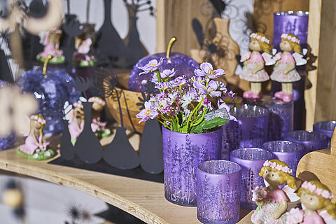 Frühlingshafte Dekoration mit violetten Lavendel-Teelichtgläsern und Blumenarrangements in der JOSKA Galeria.