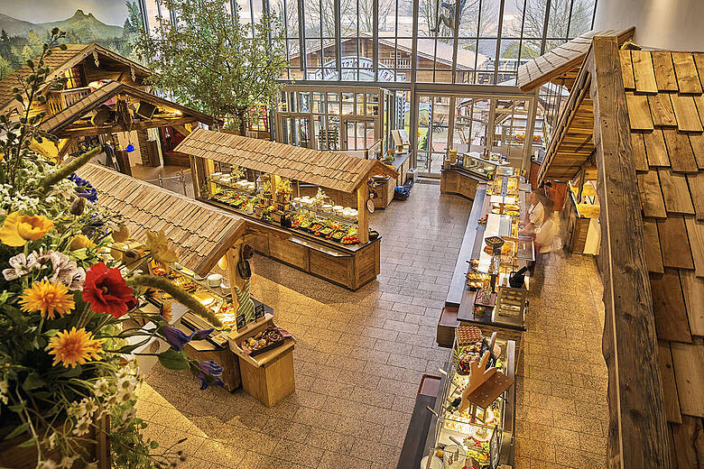 Blick von oben auf das liebevoll dekorierte Selbstbedienungsrestaurant im JOSKA Glasparadies mit Buffetstationen.