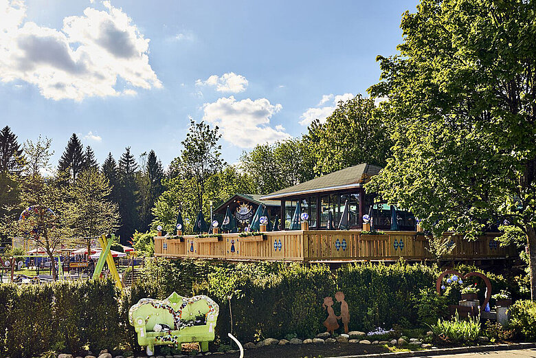 Blick auf den JOSKA Biergarten mit dem fantasievollen Gartenbereich Curioso in Bodenmais.